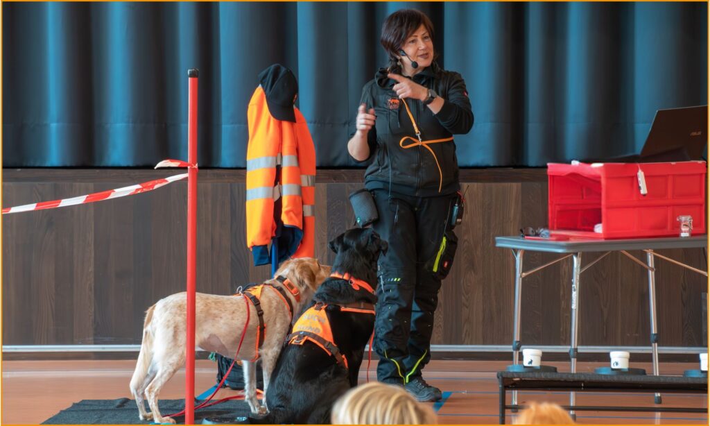 Spürhundeführerin mit Igelspürhund während einer Präsentation zur Spürhundearbeit